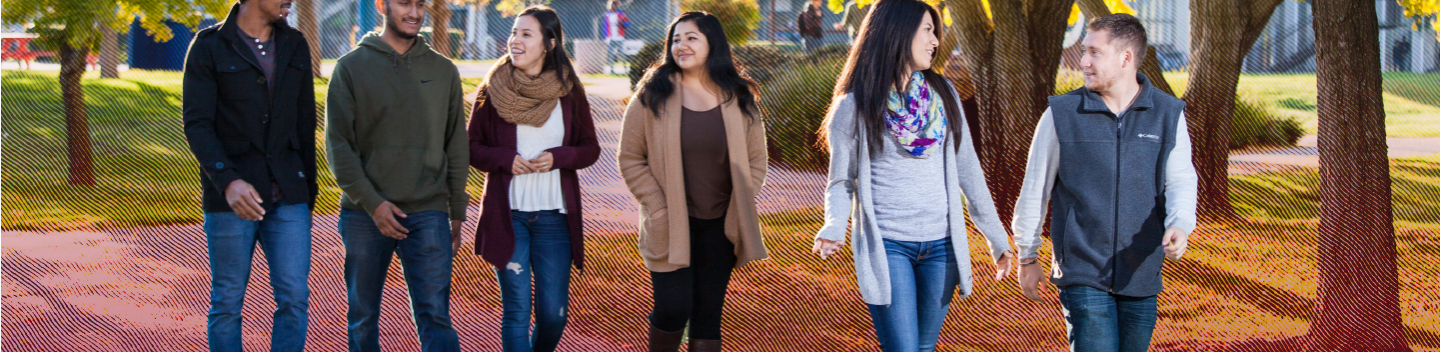 Several students walking outdoors on campus.