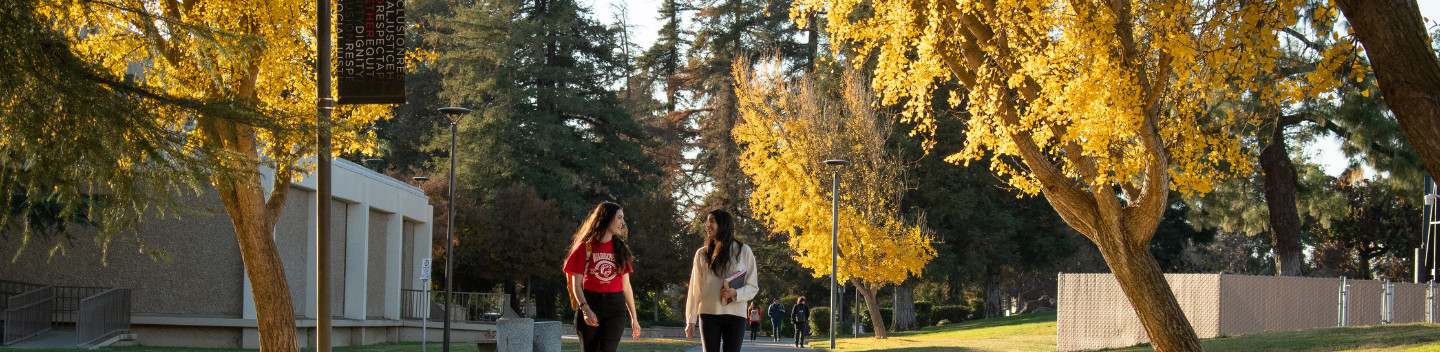 Two students walk on campus.