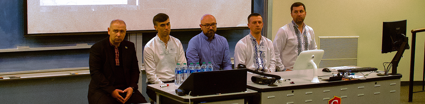 Mayors from the Ukraine stand in front of a classroom for a presentation.