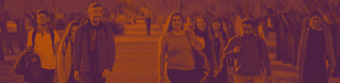 A large group of students walking outdoors on campus.