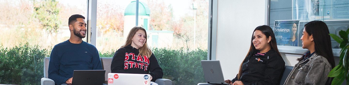 Four students studying inside a classroom building.