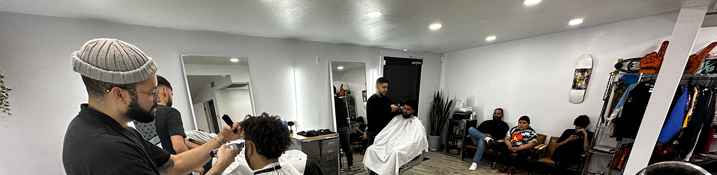 Barbers and customers getting their hair cut at a Turlock barbershop.