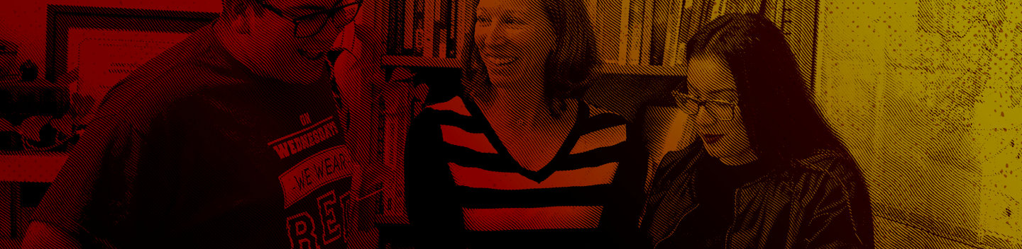 A faculty or staff members speaks to two students inside an office or classroom.