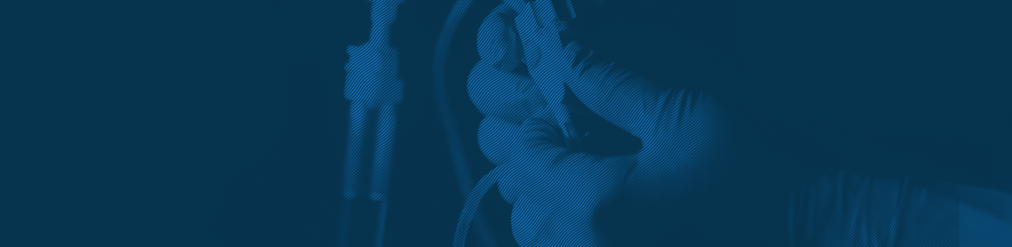 Duotone image of hands adjusting medical equipment.