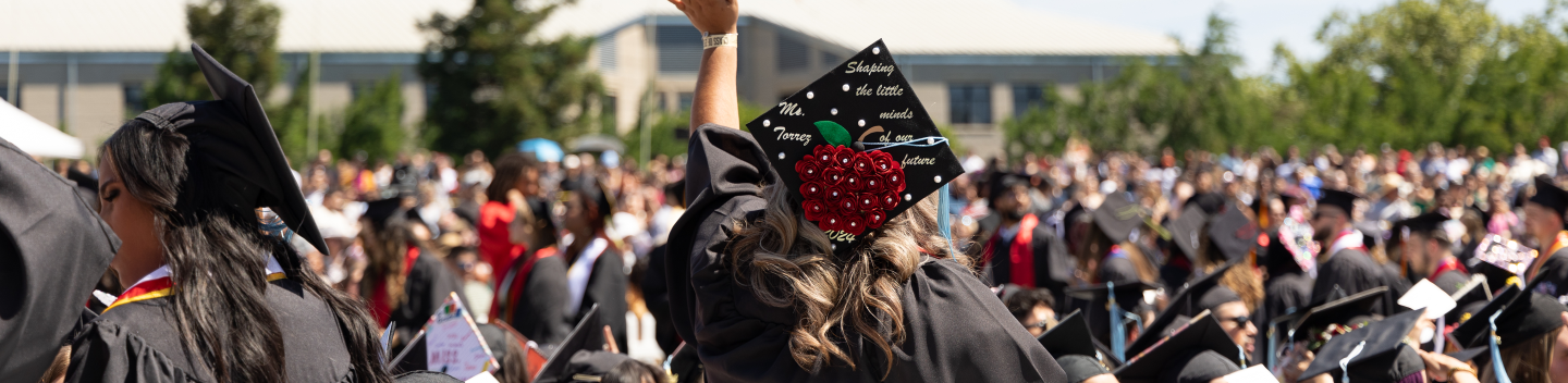Graduate waving at Commencement