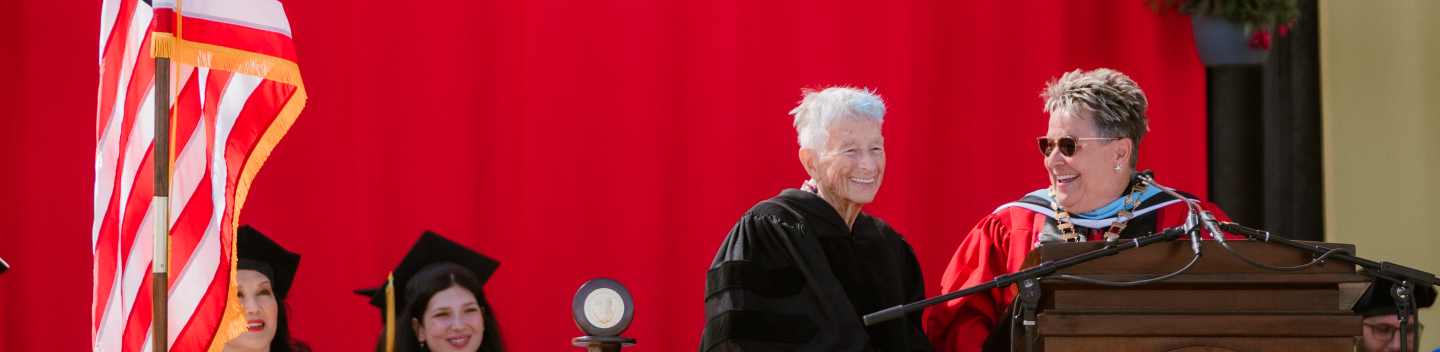 Donna Pierce at the podium with Interim President Sue Borrego during Commencement.