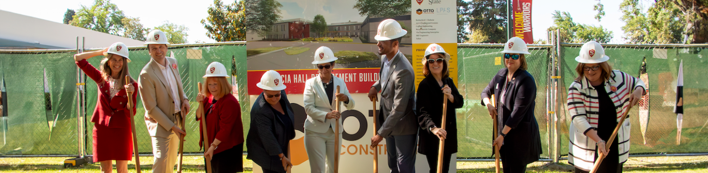 Nine dignataries from Stan State pose with shovels to celebrate the construction at Stockton Campus.