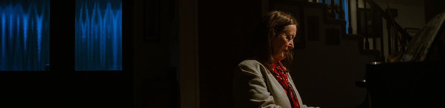 Deborah Kavasch sitting in front of a piano.