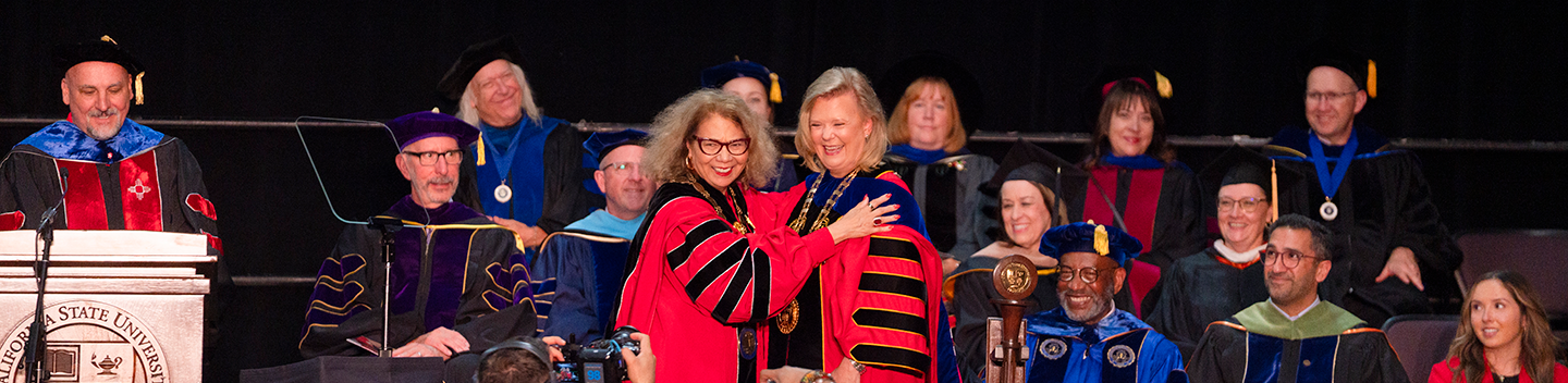 Chancellor Garcia and President Rios-Ellis pose for a picture on stage. 
