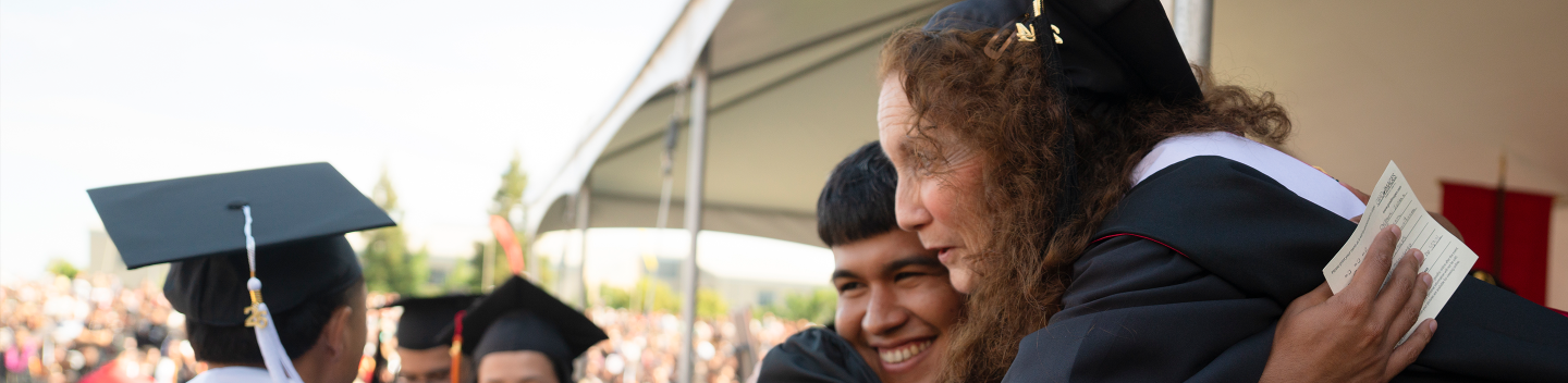 Faculty member hugs a student during Commencement.