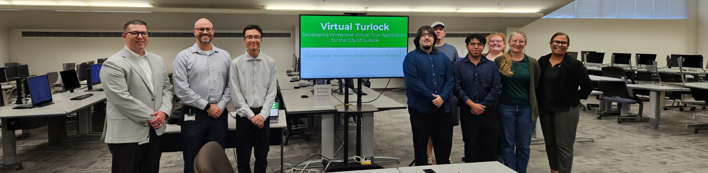 Students, staff and city partners standing together in a computer lab