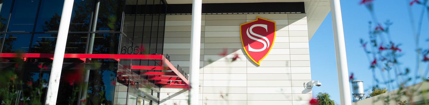 Stanislaus State shield logo displayed on the exterior of a campus building.