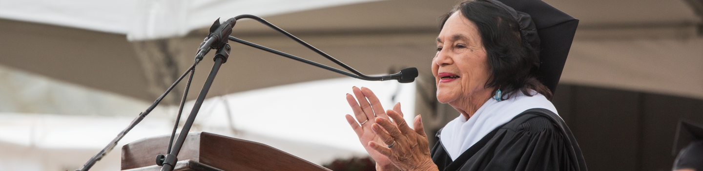 Delores Huerta stands at a lectern.