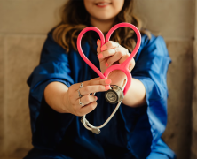 student making a heart with a stethoscope