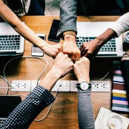 Team placing their hands together.