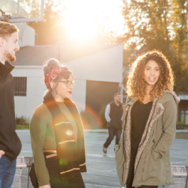 Four students gathered at a basketball court on campus.