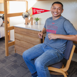 male student sitting at desk in unit