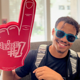 male student in the housing office with foam finger