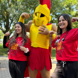 Two students pose for a picture with Titus the Warrior