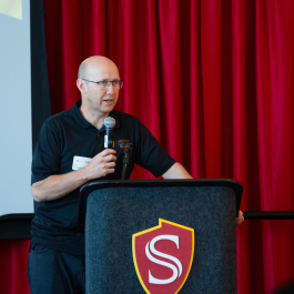 Keynote speaker speaking at a podium.