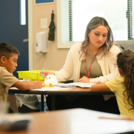 A student teacher is seen tutoring elementary school students 