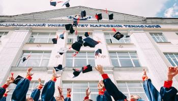 College graduates throwing caps in the air. 