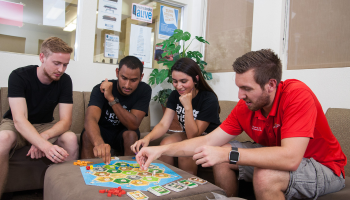 A group of students play board games at Village Housing