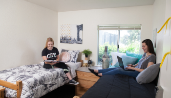Two students converse inside a dorm.