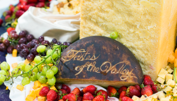 Charcuterie board with "Tastes of the Valley" carved out in a cheese block