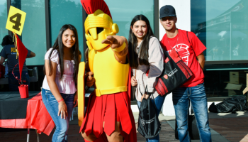 Students pose for a group photo with Titus the mascot at Warrior Expo.
