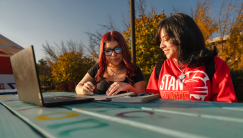 Two female students working together on a laptop