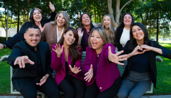 A group of Stanislaus State admissions counselors smiling and posing together outdoors on campus