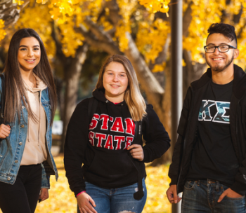 Three students in a group photo.