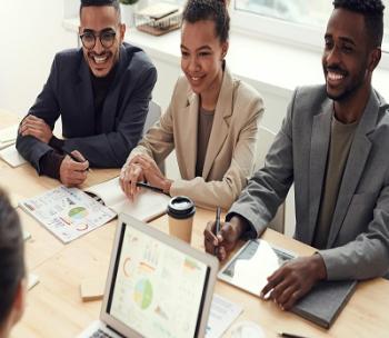 three people at a table discussing business
