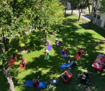 students sitting in the grass on yoga mats