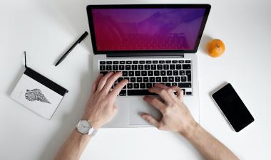 Individual typing on laptop.