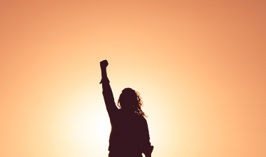 Silhouette of woman with her arm raised.