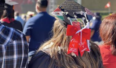Graduate student standing next to parents.