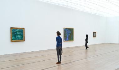 Two women staring at art pieces.