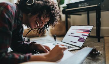 Student listening to music while working on laptop.