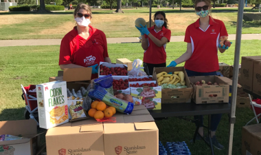 Image of staff members with boxes of fresh produce and food boxes to distribute.