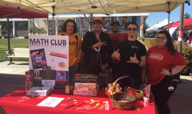 People standing behind the Math Club Booth