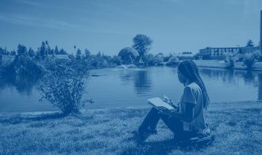 Person sitting by a lake