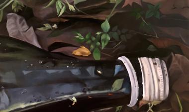 A bottle laying on top of leaves