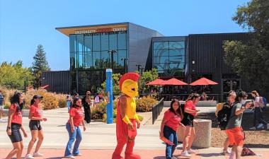 Photo of student center with students lined up to dance and Titus, the campus mascot, in the middle.
