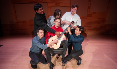students holding a guitar