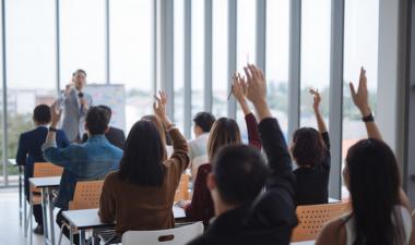 People raising their hands at a presentation