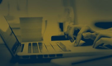 Hands typing on a laptop computer.