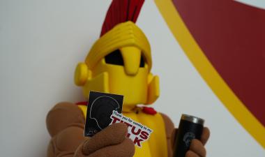 Titus Mascot holding stickers and tumbler