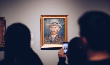 People looking at a portrait of Van Gogh